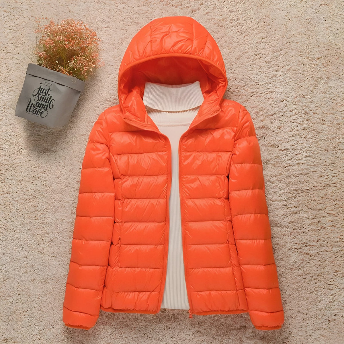 Women's Compressible Hiking Down Jacket staged with plant - Powder Pink - Navy Blue - Navy Blue (without hood) - Orange - Beige - Beige (without hood) - Mint Green - Mint Green (without hood) - Pink - Blue - Purple - Purple (without hood) - Red - Red (without hood) - Black - Black (without hood) - Burgundy - Burgundy (without hood)